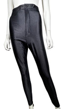 Load image into Gallery viewer, This American Apparel legging pant is a rare gem - shiny, black, and equipped with two back pockets. It may have a bit of wear on the inner upper thigh, but it&#39;s still a winner. The waist measures 28&quot;, the hips 32&quot;, and the inseam is 28&quot;, with a length of 39&quot;.