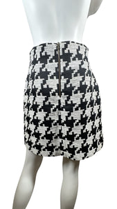 Indulge in the classic and timeless style of the Black and White Houndstooth Skirt. This skirt features a striking houndstooth print, zipper closure, and measured flat waist of 28 inches. With a hip measurement of 37 inches and a flattering length of 1...