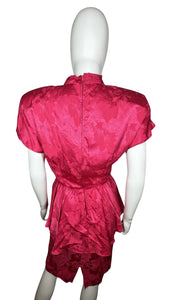 An 80’s vintage bright pink peplum dress with floral print on the silk. Measured Flat Chest- 32” Waist- 26” Hips- 36” Length- 41”