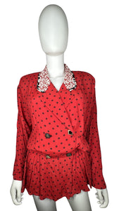 This large vintage Carole Little blazer rocks a bold red color, featuring a peplum bottom, a flowery collar, and charming decorative buttons. When flattened, it measures 42" around the chest, with 22" sleeves, a 26" waist, and a 29" length.