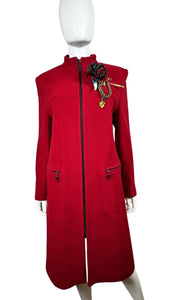 The Vintage KronHaus Coat is a luxurious, bespoke red wool coat. Its unique vintage charm is further enhanced by subtle imperfections near the button zipper area, as shown in the picture. The chest measures 39 inches when laid flat, and the sleeves are...