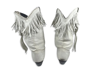 These ACME cowgirl boots from the 80's are a unique find, with their white color and fringes. While the size is unknown, the boot length measures 10 inches, which typically translates to a size 8 or 9. Since they're vintage, they may run a bit smaller...