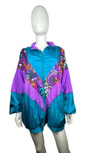 Load image into Gallery viewer, This Vintage Just For Women Windbreaker Jacket is perfect for those who like to mix things up. In bold Teal and purple, this 90&#39;s jacket has an oversized fit that measures 46&quot; at the chest, with 25&quot; sleeves and a length of 29&quot;.