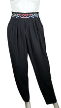 Load image into Gallery viewer, Introducing the Black Tribal Pant: a high-waisted harem style pant with tribal-inspired embroidery along the waistline. With a stretchy waistband in the back, you&#39;ll feel comfortable and stylish all day long. Measured flat, the waist is 29 inches, the...