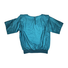 Load image into Gallery viewer, Get ready to add some retro flair to your wardrobe with this Vintage Novelle 80s Teal Blouse! Featuring a stretch waist band and shoulder pads, this blouse will give you a bold and unique look. When laid flat, it measures 42&quot; at the chest and has a len...