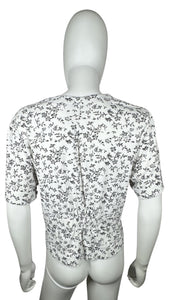 Experience a touch of nostalgia with our Vintage Black and White Floral Crop Top - the perfect blend of old and new. This short sleeve button-up piece features a chest measurement of 34" and a length of 19", giving you a flattering fit.