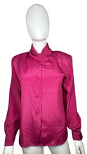 Load image into Gallery viewer, The Pierre Cardin blouse from the 80&#39;s has a playful magenta color and a silky feel. It features shoulder pads and a buttoned collar, and when measured flat, has a chest of 35&quot;, sleeve of 23&quot;, and length of 25&quot;.