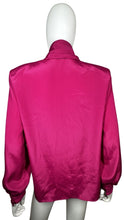 Load image into Gallery viewer, The Pierre Cardin blouse from the 80&#39;s has a playful magenta color and a silky feel. It features shoulder pads and a buttoned collar, and when measured flat, has a chest of 35&quot;, sleeve of 23&quot;, and length of 25&quot;.