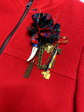 Load image into Gallery viewer, The Vintage KronHaus Coat is a luxurious, bespoke red wool coat. Its unique vintage charm is further enhanced by subtle imperfections near the button zipper area, as shown in the picture. The chest measures 39 inches when laid flat, and the sleeves are...