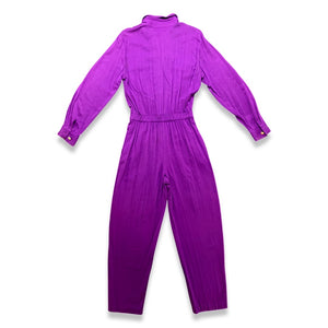 This rare find Vintage 80's Saint Germain Jumpsuit is a vintage purple button up jumpsuit with gold stitching and embellishing with a stretch waist. Measured Flat Sleeve - 24" Waist - 26" Hips - 36" Length - 58"